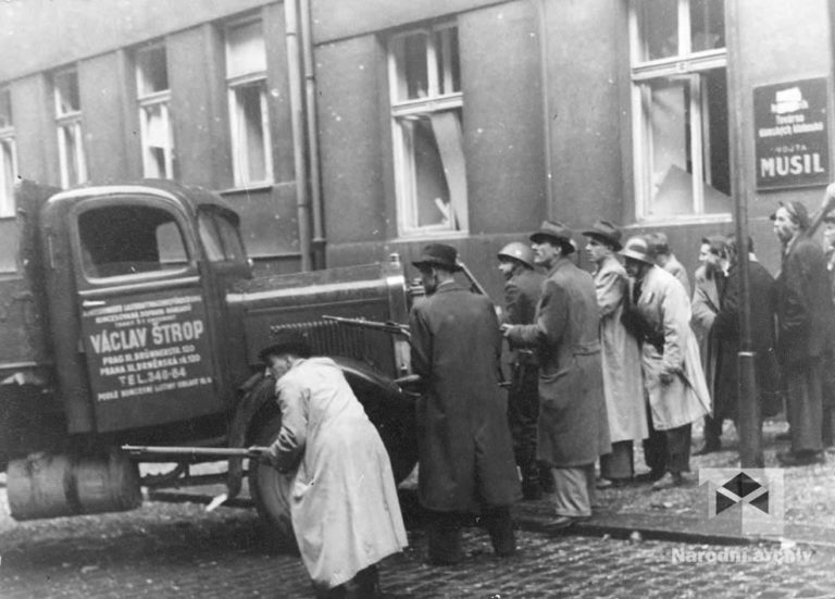 Esesáci brání v přístupu do budovy rozhlasu. Povstalci do budovy ale pronikají z Balbínovy ulice a po střechách okolních domů.