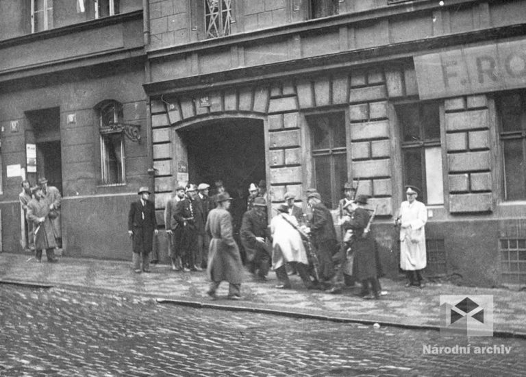 Esesáci brání v přístupu do budovy rozhlasu. Povstalci do budovy ale pronikají z Balbínovy ulice a po střechách okolních domů.